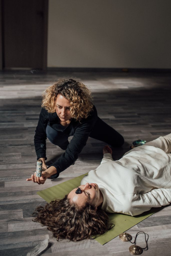 A spiritual healing session indoors with sage cleansing and energy balancing.